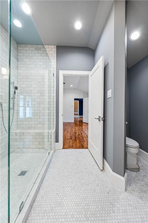 bathroom featuring hardwood / wood-style flooring, toilet, and a shower with door