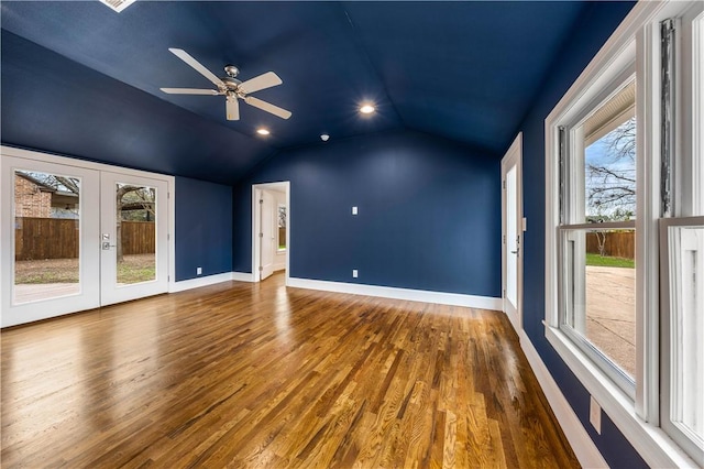 unfurnished living room featuring lofted ceiling, hardwood / wood-style floors, a healthy amount of sunlight, and french doors