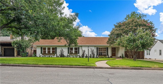 ranch-style home with a garage and a front lawn