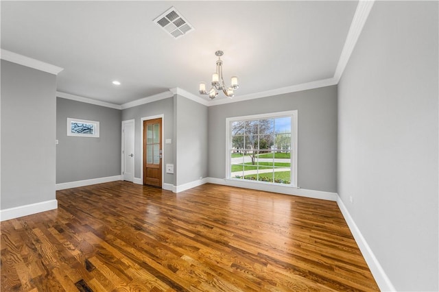 empty room featuring ornamental molding, an inviting chandelier, and dark wood-type flooring