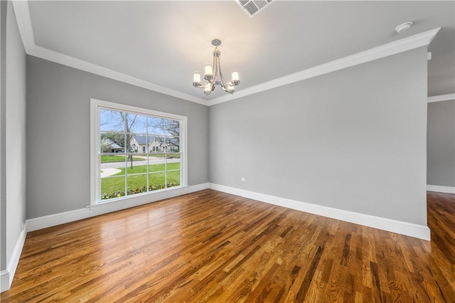 unfurnished room featuring crown molding, wood-type flooring, and an inviting chandelier