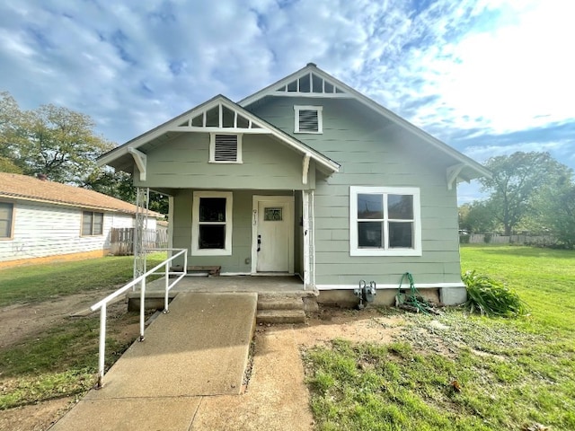 bungalow with covered porch and a front lawn