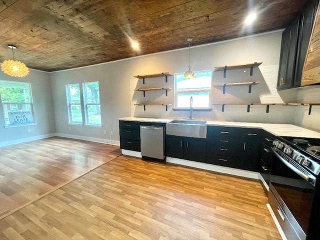 kitchen featuring appliances with stainless steel finishes, dark cabinets, light wood-type flooring, open shelves, and a sink