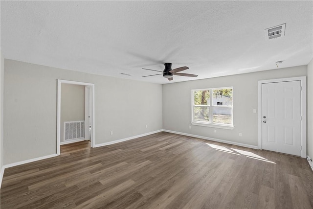 spare room featuring a textured ceiling, ceiling fan, and dark wood-type flooring