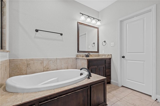 bathroom featuring tile patterned flooring, vanity, and a tub to relax in