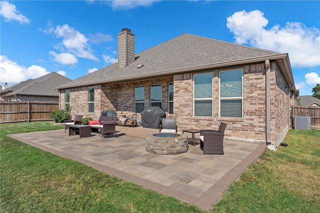 back of house featuring an outdoor living space with a fire pit, a patio area, and a lawn