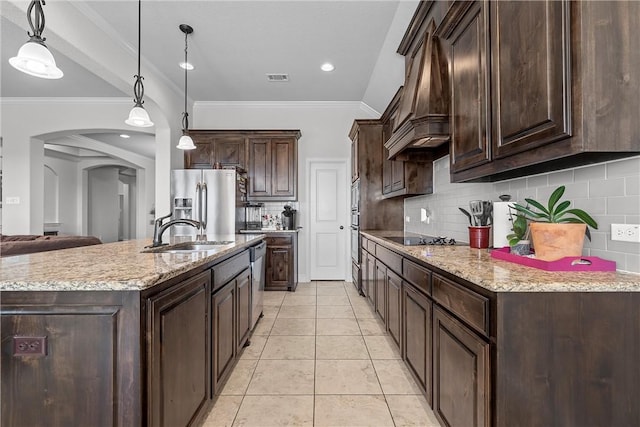 kitchen featuring stainless steel appliances, dark brown cabinets, sink, and pendant lighting