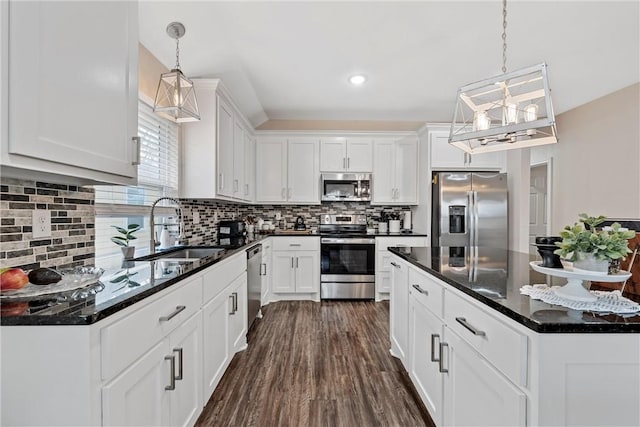 kitchen featuring pendant lighting, dark wood-type flooring, white cabinets, sink, and appliances with stainless steel finishes