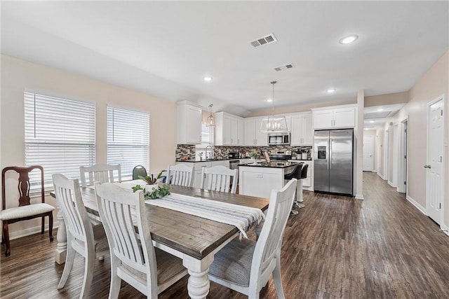 dining space with sink and dark wood-type flooring