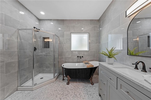 bathroom with vanity, tile walls, and independent shower and bath