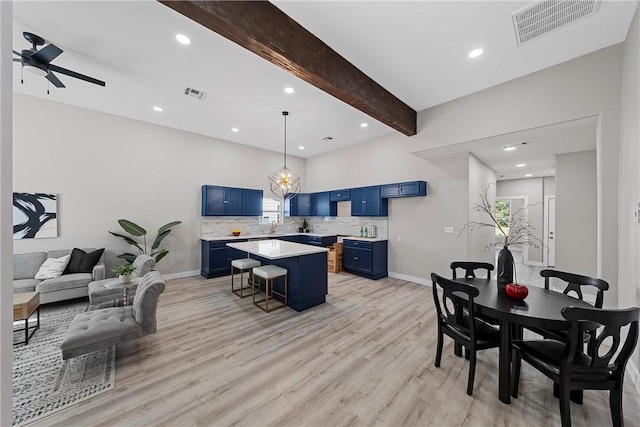 interior space with a kitchen breakfast bar, a center island, light hardwood / wood-style flooring, and blue cabinets