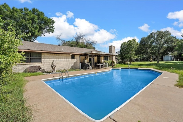 view of swimming pool with a yard and a patio