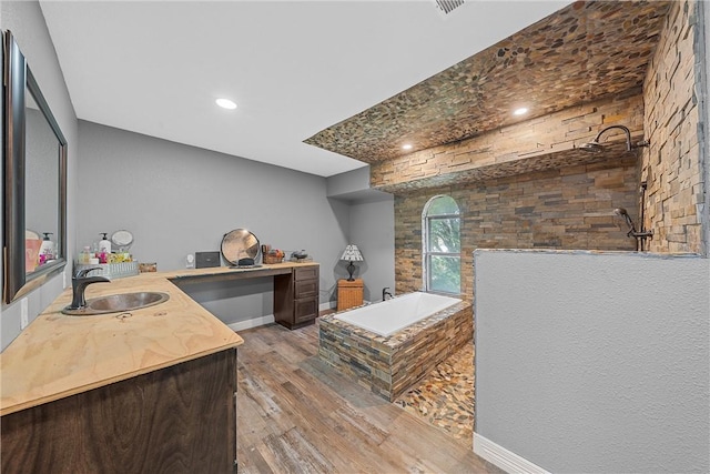 bathroom featuring plus walk in shower, hardwood / wood-style floors, and vanity