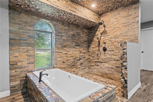 bathroom featuring tiled bath and hardwood / wood-style floors