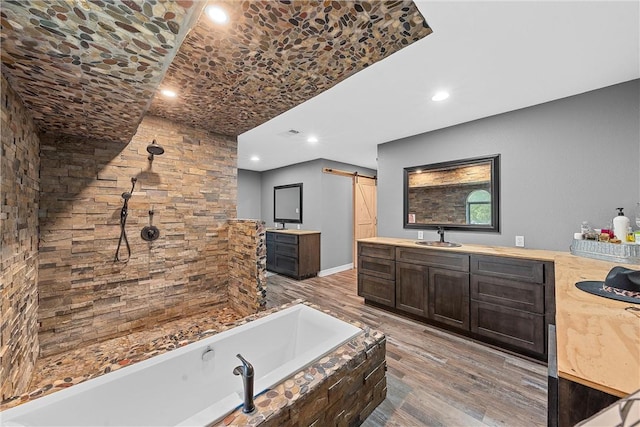 bathroom featuring vanity, a bath, and hardwood / wood-style flooring