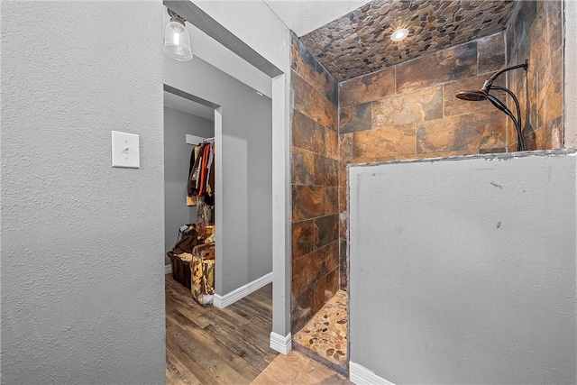 bathroom featuring tiled shower and hardwood / wood-style flooring