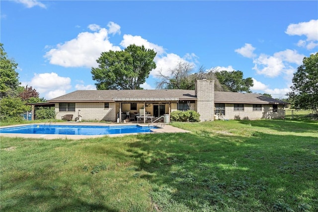 rear view of house featuring a lawn and a patio area