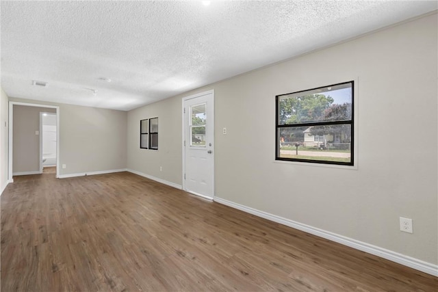 empty room with hardwood / wood-style flooring and a textured ceiling