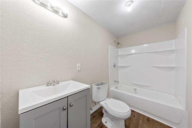 full bathroom featuring a textured ceiling, toilet, vanity, bathtub / shower combination, and hardwood / wood-style flooring