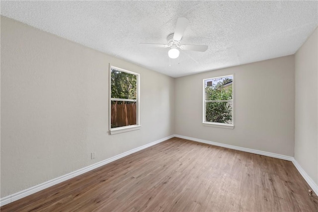 spare room with plenty of natural light, wood-type flooring, and a textured ceiling