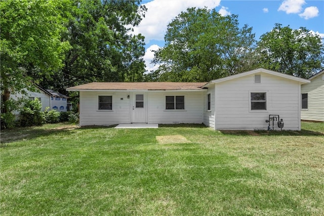 rear view of property with a lawn