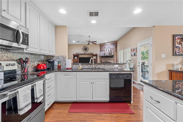 kitchen with kitchen peninsula, white cabinetry, and appliances with stainless steel finishes