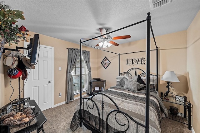 carpeted bedroom featuring ceiling fan and a textured ceiling