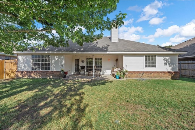 back of property with a lawn and a patio