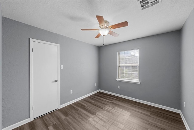 spare room with hardwood / wood-style flooring, ceiling fan, and a textured ceiling