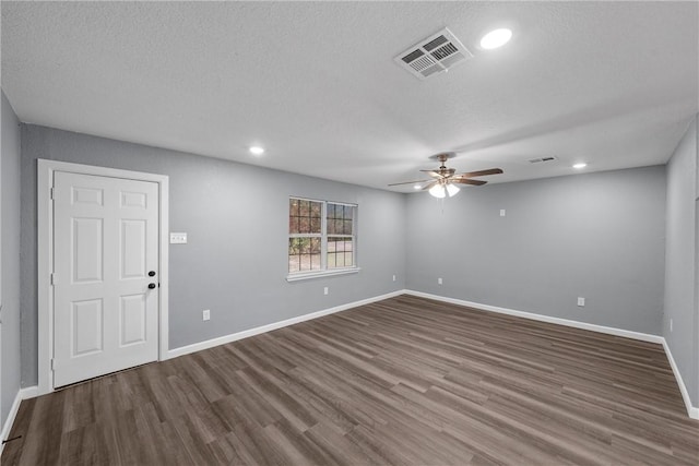 empty room with ceiling fan, wood-type flooring, and a textured ceiling