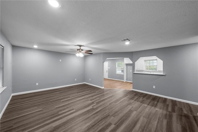 empty room featuring a textured ceiling, dark hardwood / wood-style floors, and ceiling fan