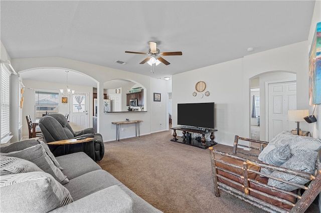 carpeted living room featuring ceiling fan with notable chandelier and lofted ceiling