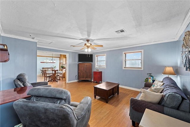 living area featuring visible vents, ceiling fan, wood finished floors, crown molding, and a textured ceiling