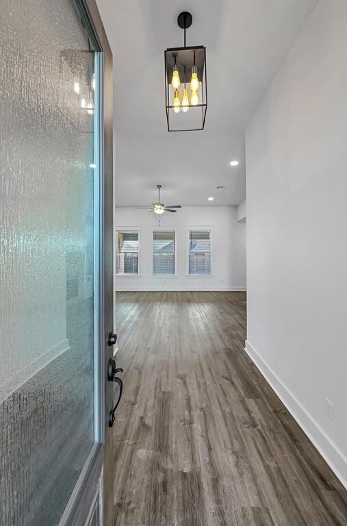 hall with wood-type flooring and an inviting chandelier