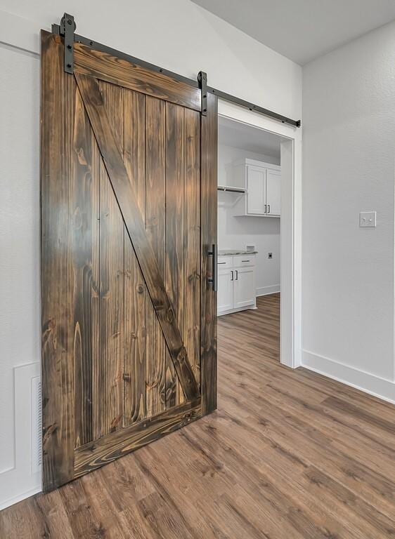 room details with a barn door and wood-type flooring