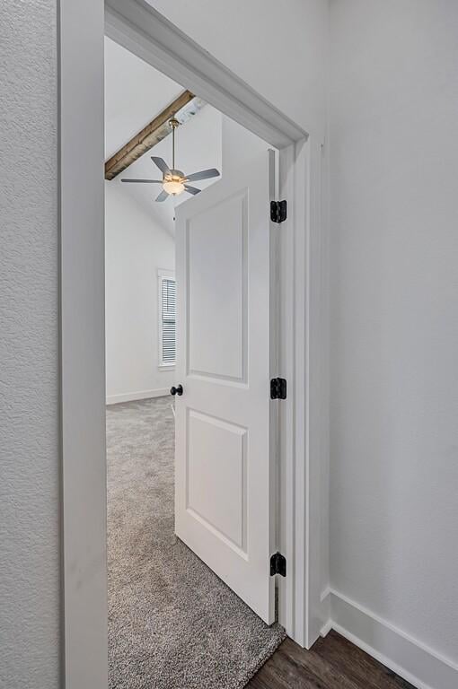 corridor featuring lofted ceiling with beams and dark wood-type flooring