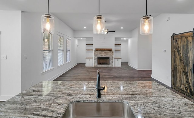 kitchen with a barn door, decorative light fixtures, and sink