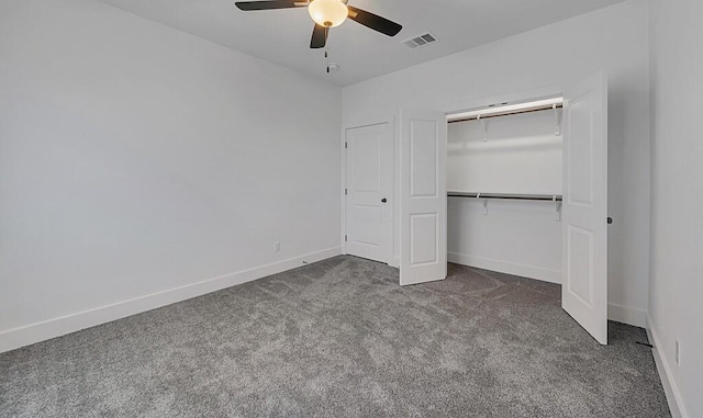 unfurnished bedroom featuring dark colored carpet, ceiling fan, and a closet