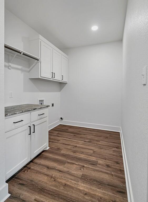 laundry area featuring cabinets, electric dryer hookup, dark hardwood / wood-style flooring, and hookup for a washing machine