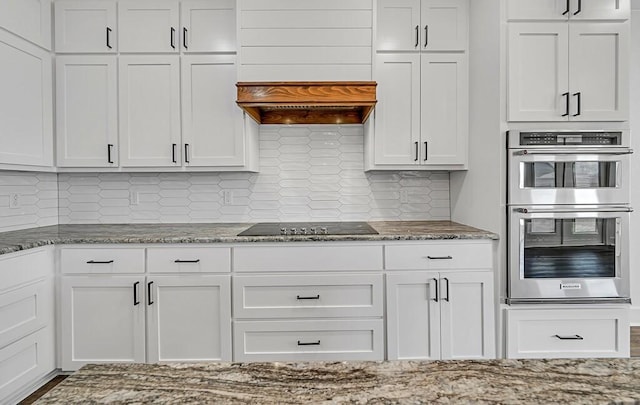 kitchen featuring white cabinetry, stainless steel double oven, black electric cooktop, and backsplash