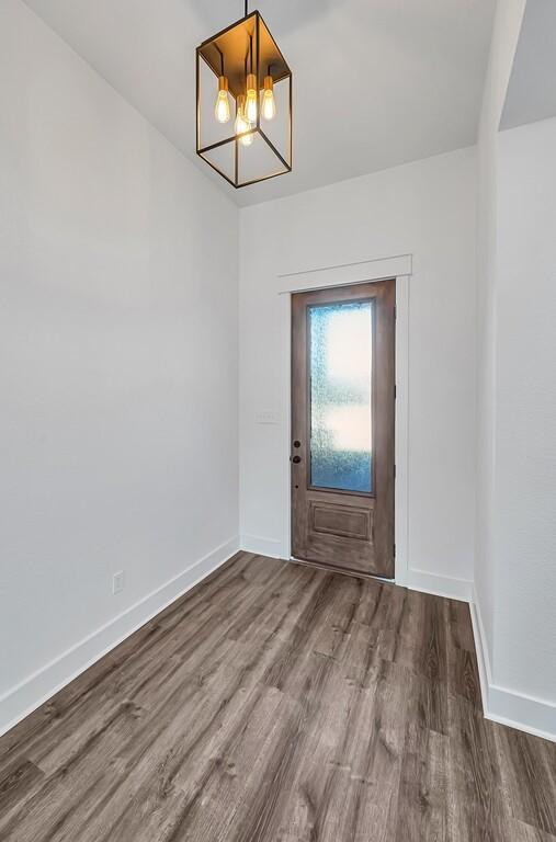 interior space with wood-type flooring and an inviting chandelier