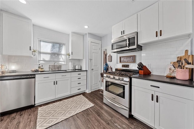 kitchen featuring dark hardwood / wood-style flooring, sink, white cabinetry, and stainless steel appliances