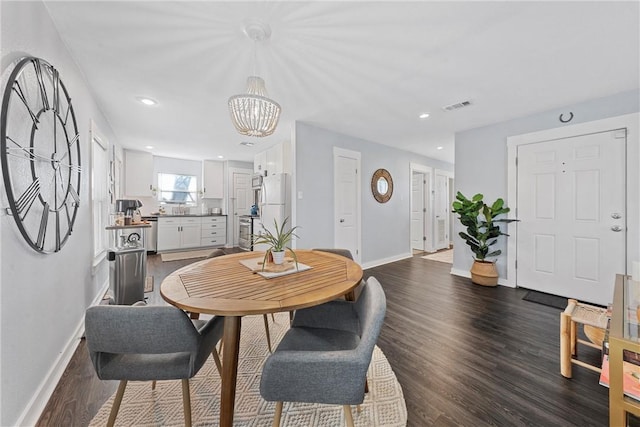 dining space with a notable chandelier and dark hardwood / wood-style flooring