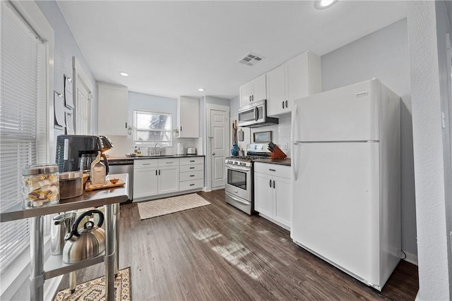 kitchen with white cabinetry, dark wood-type flooring, stainless steel appliances, and sink