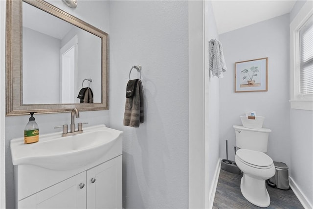 bathroom with hardwood / wood-style floors, vanity, and toilet