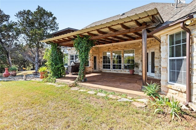 back of house featuring a lawn and a patio area