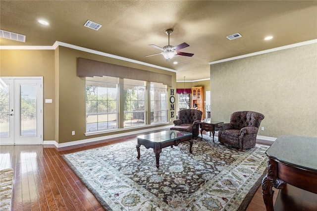 living room featuring french doors, a textured ceiling, ceiling fan, crown molding, and hardwood / wood-style flooring