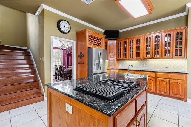 kitchen featuring sink, black gas cooktop, stainless steel fridge, an island with sink, and ornamental molding