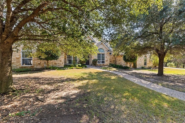 view of property hidden behind natural elements with a front yard