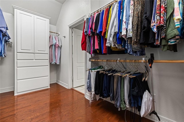 walk in closet with hardwood / wood-style floors and vaulted ceiling